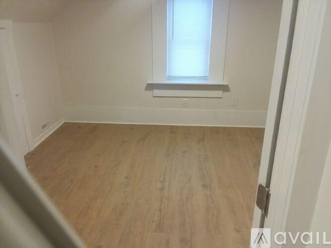 A room with wooden flooring and a window.