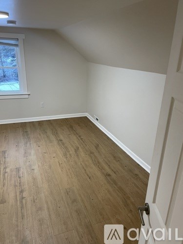 A room with wooden flooring and a window.
