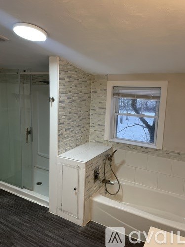 A bathroom with a window showing trees outside.