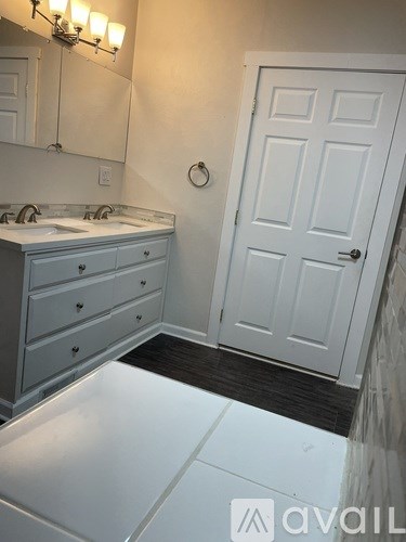 A bathroom with a white door and a white sink.