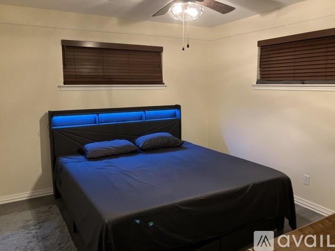 A bed with a blue light strip under the headboard.
