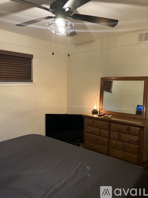 A bedroom with a bed, dresser, and mirror.