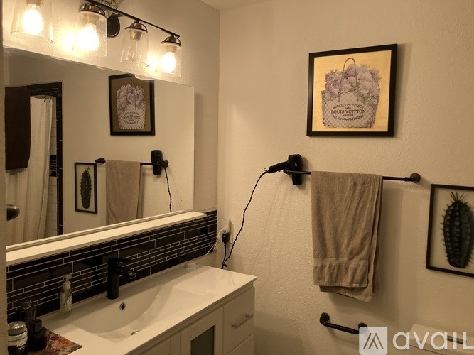 A bathroom with a white sink and a mirror above it.