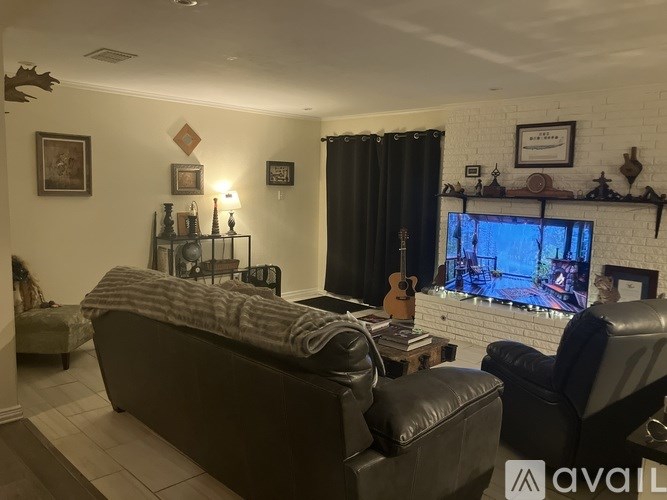 A living room with a large couch, a chair, and a television.