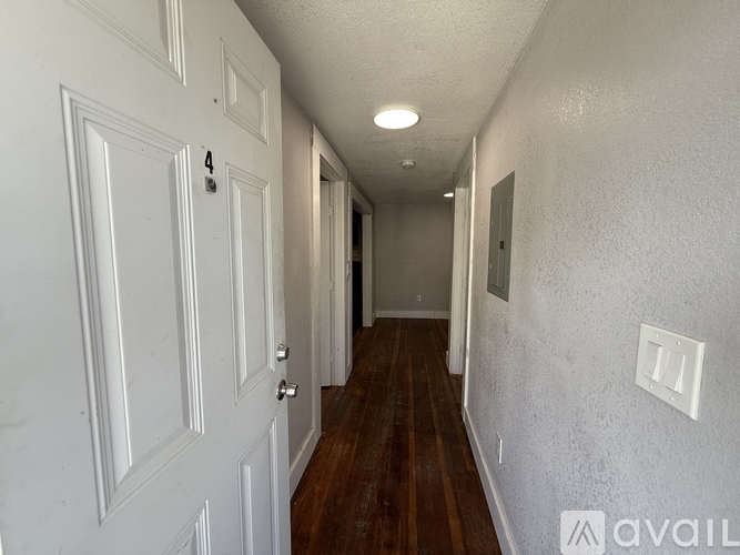 A room with wooden flooring and a window with blinds.