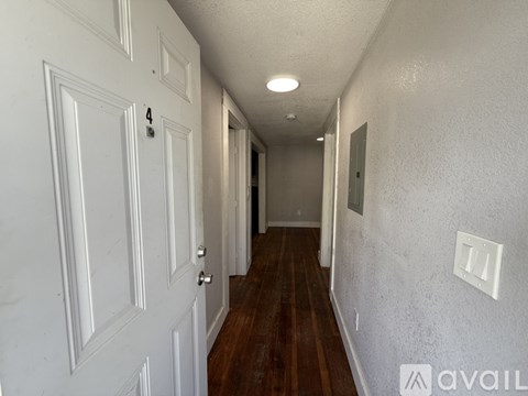 A room with wooden flooring and a window with blinds.