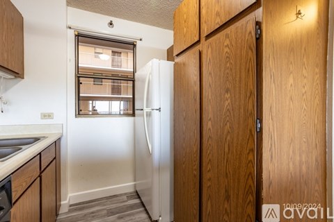 A kitchen with wooden cabinets and a white fridge.