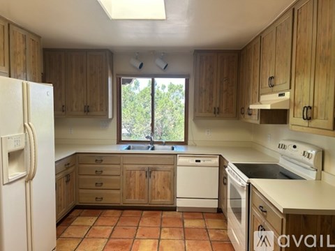 A kitchen with wooden cabinets and a white refrigerator.