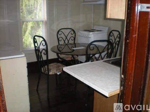 A kitchen with a table and chairs.