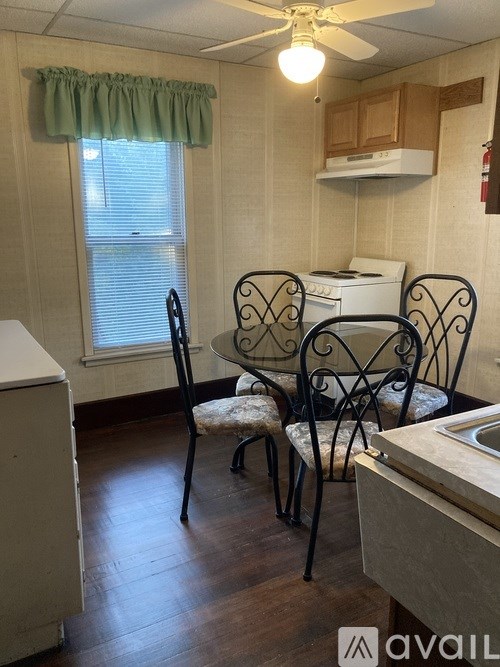 A kitchen with a table and chairs.