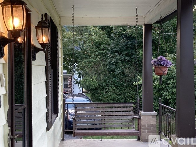 A room with a wooden floor and a white bed.