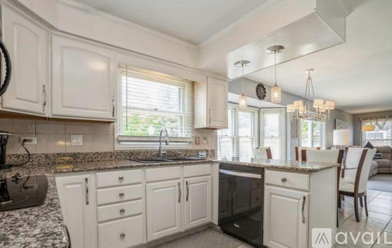 A kitchen with white cabinets and a black oven.