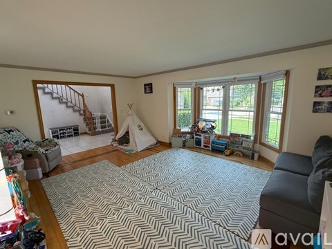 A living room with a grey sofa and a rug with a chevron pattern.