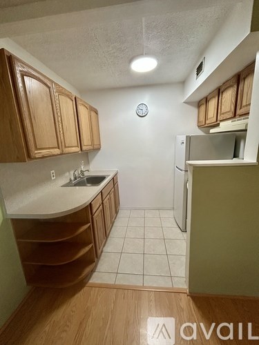 A kitchen with wooden cabinets and a white fridge.