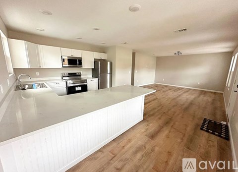 A kitchen with white cabinets and a white countertop.
