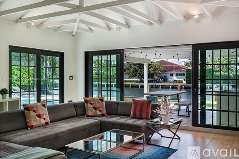 A living room with a grey couch and a glass table.
