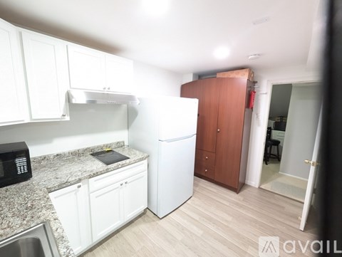 A kitchen with white cabinets and a granite countertop.