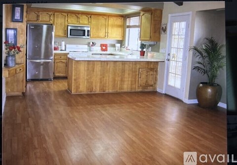 A kitchen with wooden cabinets and a refrigerator.