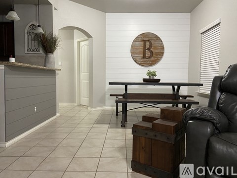 A modern living room with a wooden table and a black leather chair.