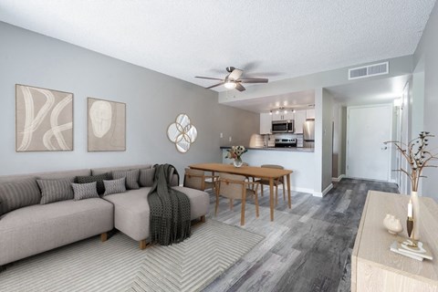 A living room with a grey couch and a wooden table.