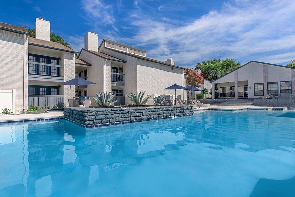 A swimming pool in front of a modern house.
