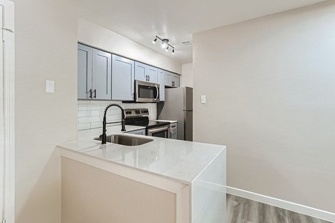 A kitchen with a sink and a microwave.