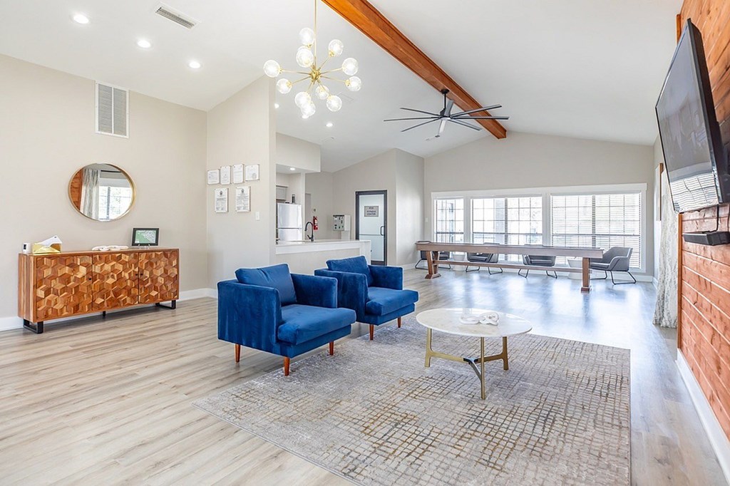 A living room with a blue sofa and a wooden floor.