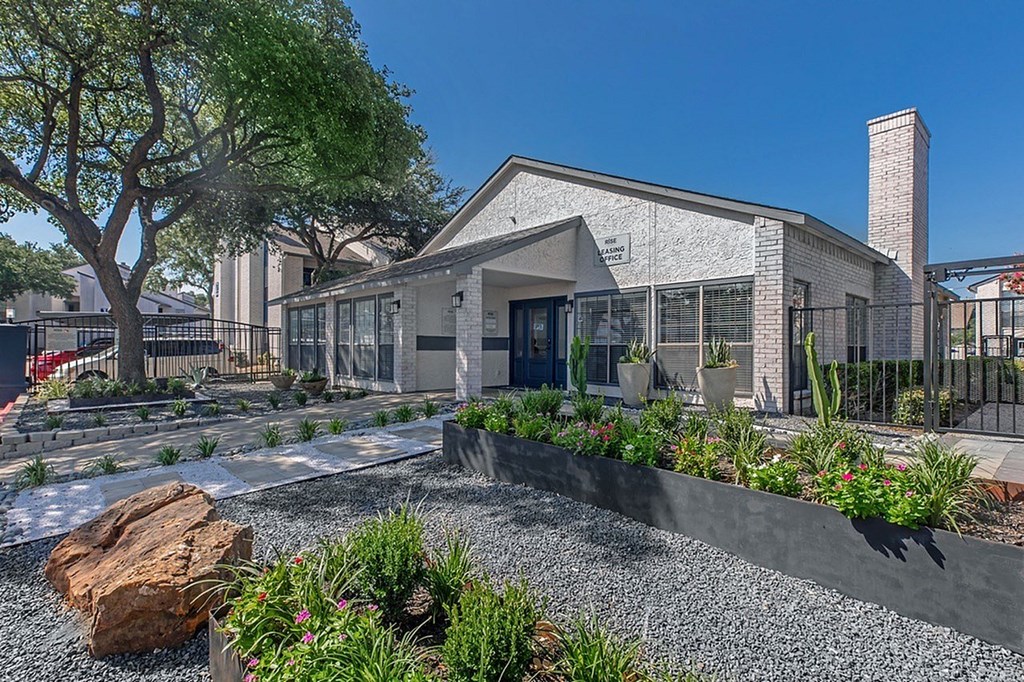 A modern house with a grey exterior and a black fence.
