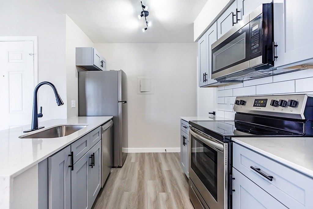 A kitchen with a black microwave above the stove.
