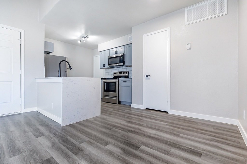 A kitchen with a white countertop and a stainless steel oven.