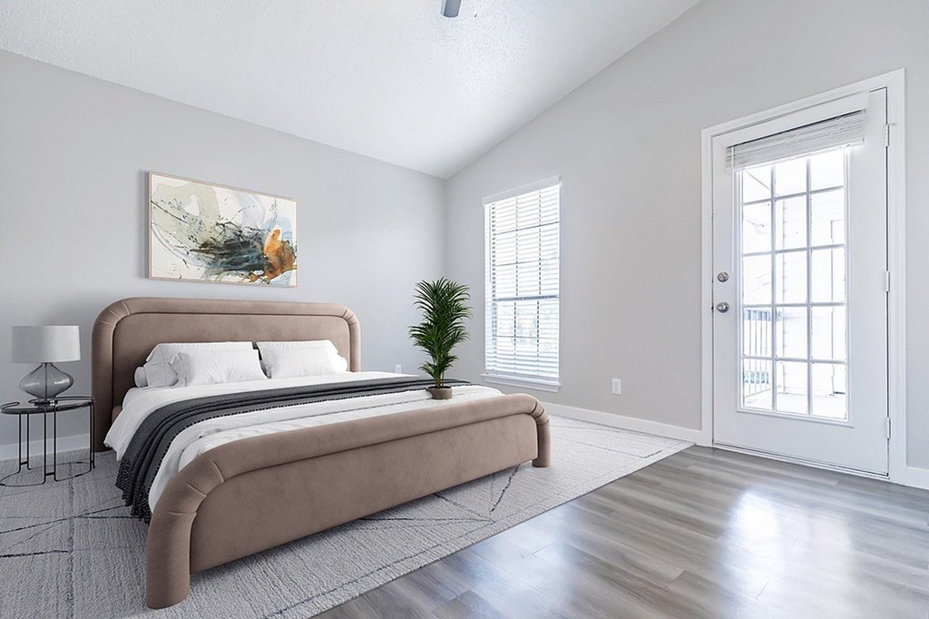 A bedroom with a large bed and a painting on the wall.