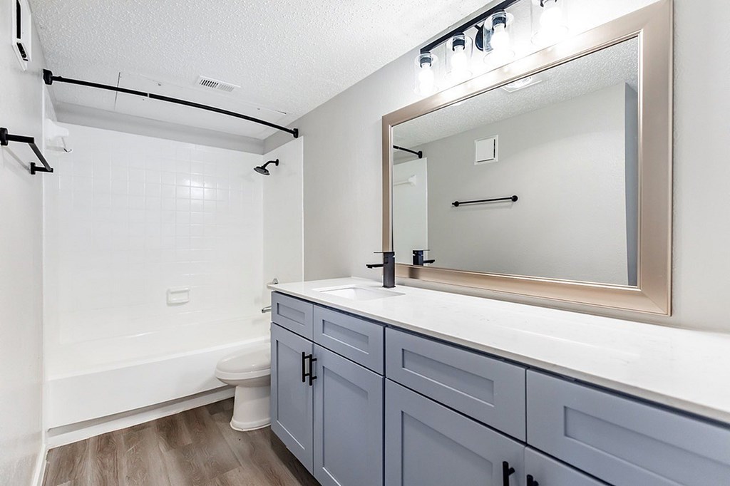 A bathroom with a white tub and a large mirror.