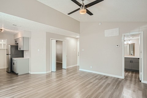 A spacious room with a ceiling fan and wooden flooring.