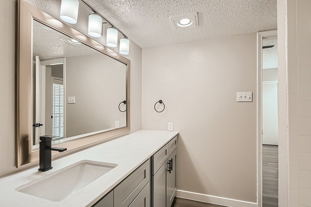 A bathroom with a sink and mirror.