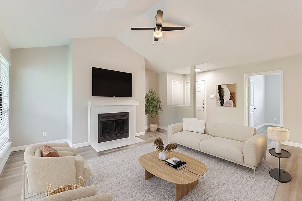 A living room with a fireplace and a television.