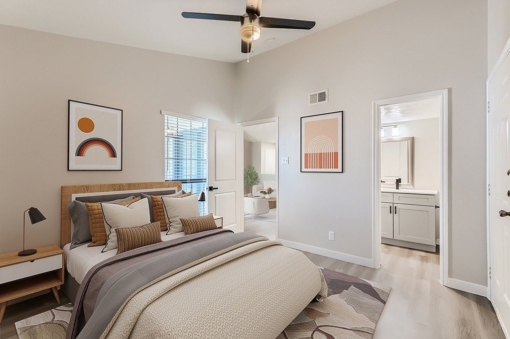 A bedroom with a large bed and a ceiling fan.