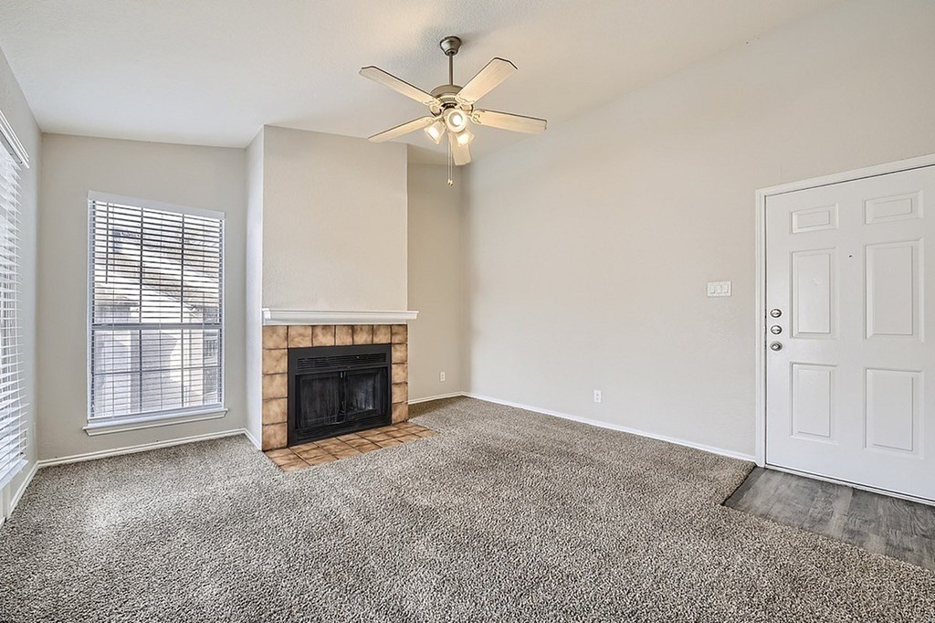 A room with a fireplace and a ceiling fan.
