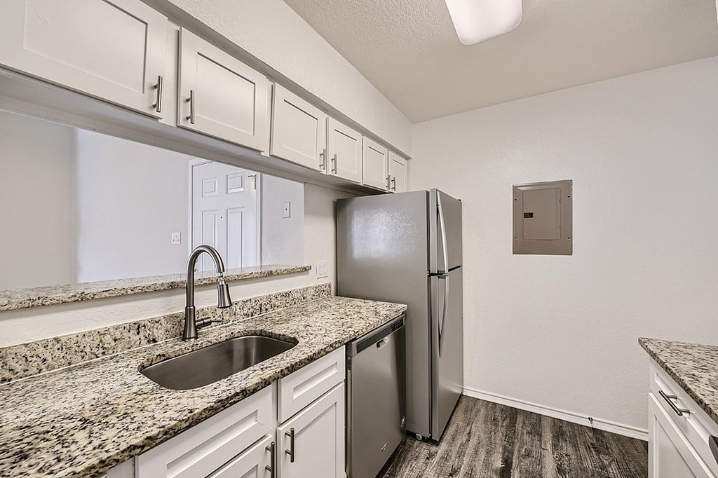 A kitchen with granite countertops and stainless steel appliances.