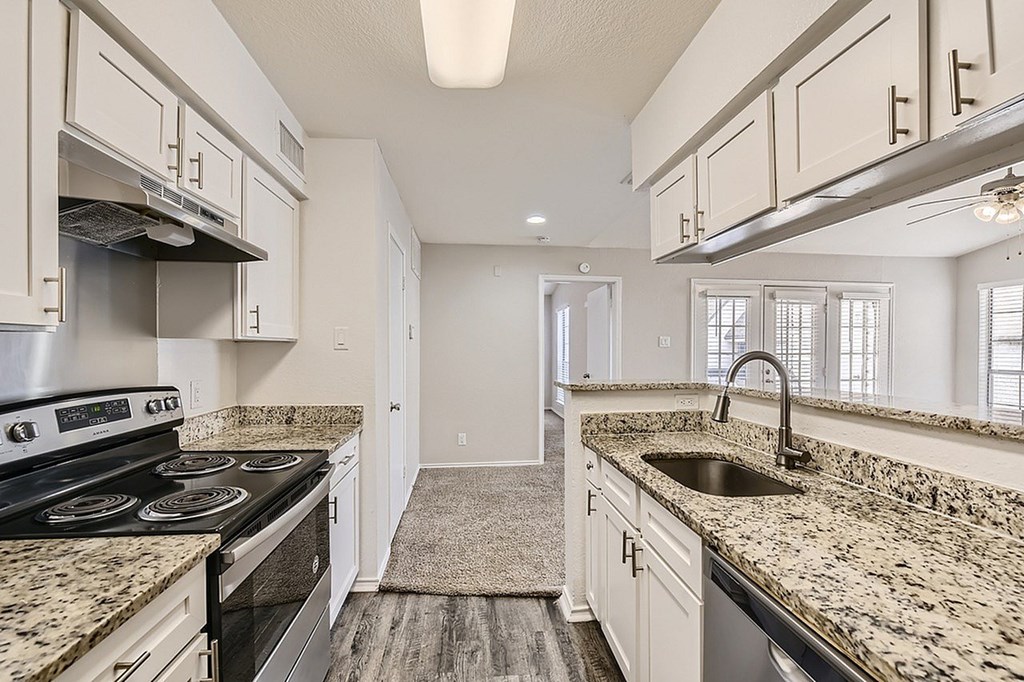 A kitchen with granite countertops and stainless steel appliances.