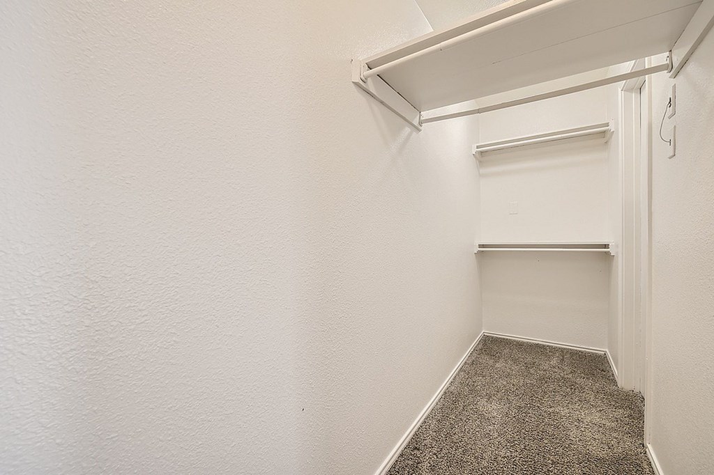 A white room with a carpeted floor and a white door.
