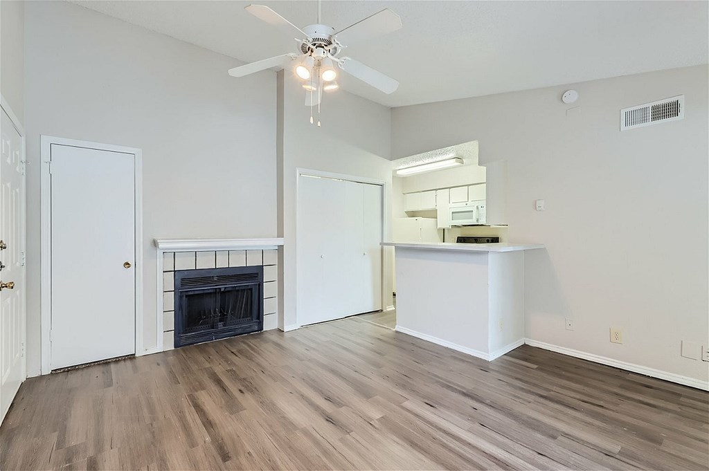 A room with a fireplace and a ceiling fan.