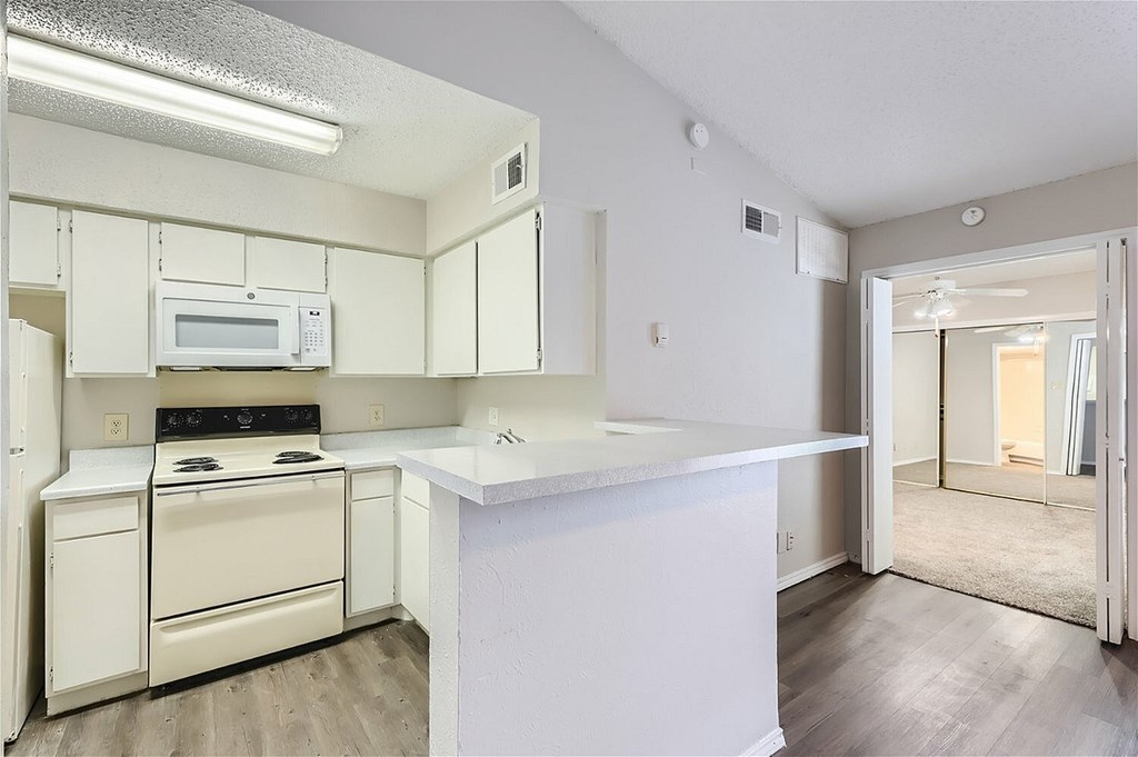 A kitchen with white appliances and cabinets.