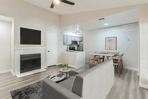 A living room with a grey couch and a fireplace.