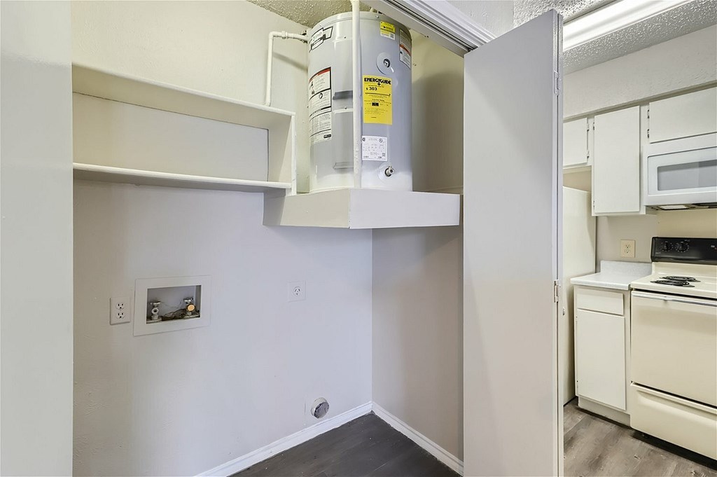 A white refrigerator is in a kitchen with white cabinets.