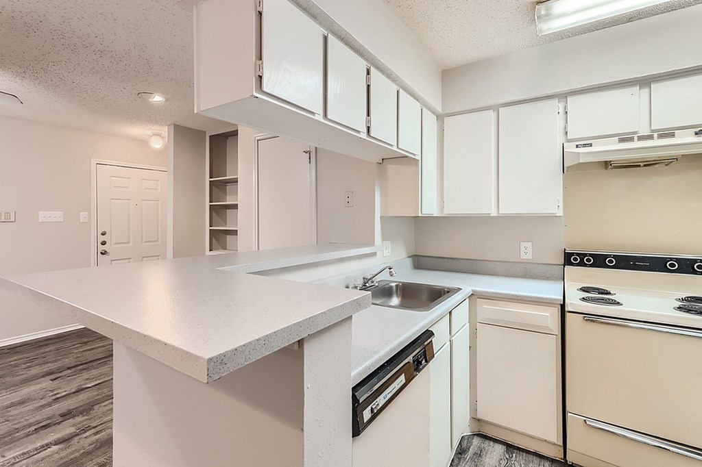 A kitchen with white cabinets and appliances.