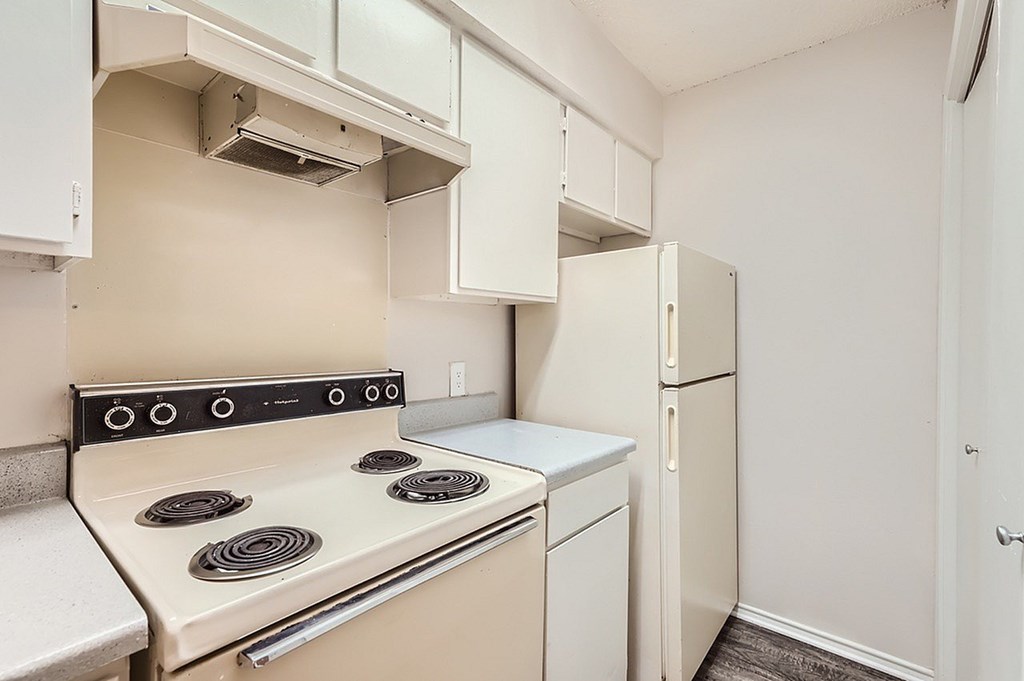 A white kitchen with a stove top oven and a dishwasher.