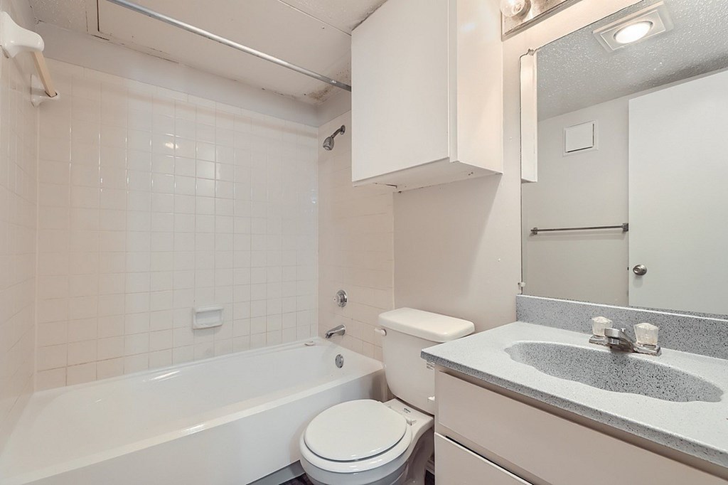 A white bathroom with a toilet, sink, and bathtub.