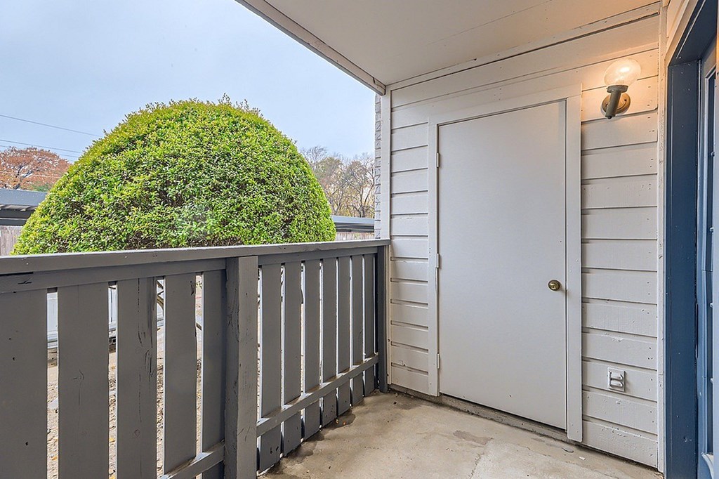 A white door is on the right side of a grey railing.