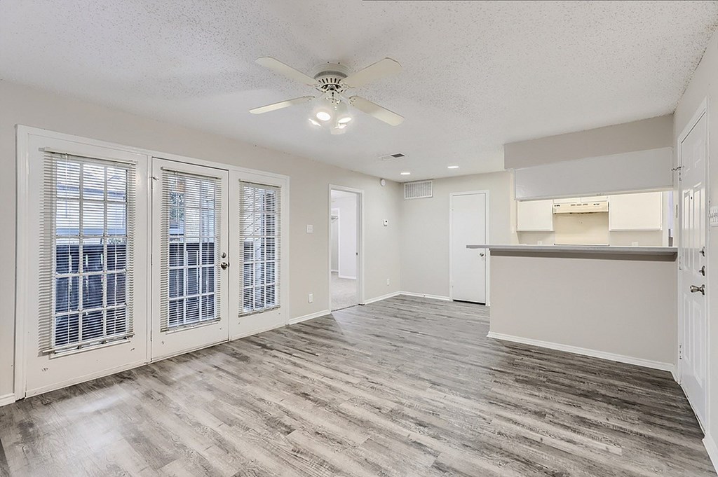A room with a ceiling fan and a window with blinds.