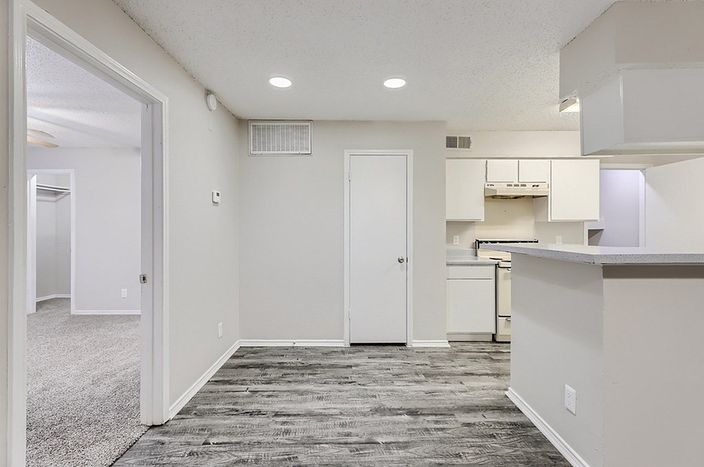 A kitchen area with a white door and a white cabinet.